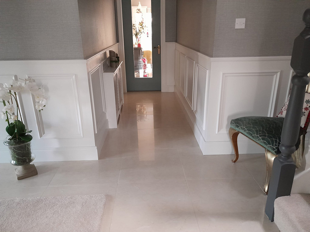 Entrance hallway with textured grey wallpaper, white wall panelling and off white tiles